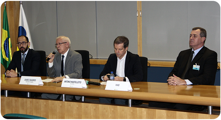 Imagem da mesa da coletiva com os participantes