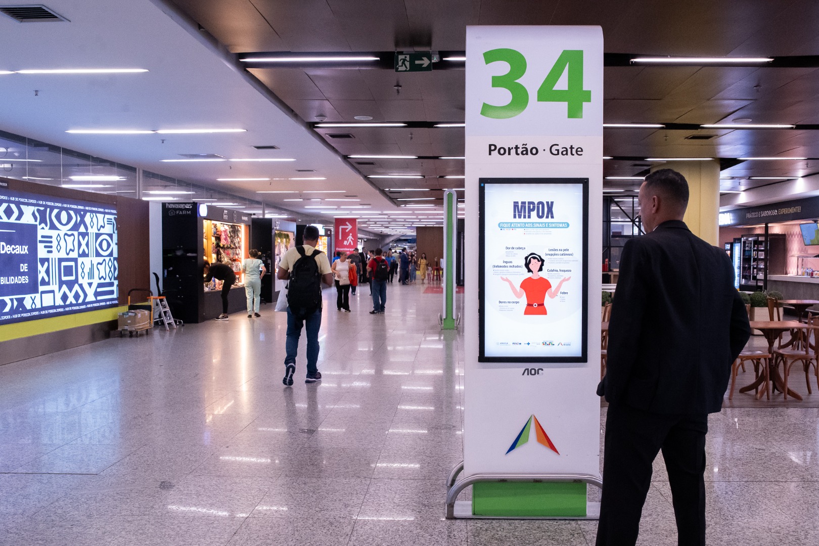 Viajante observa painel com aviso de Mpox no aeroporto de Brasília