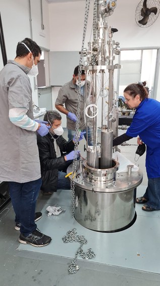 Criostato de argônio PULARC (Purification Liquid Argon Cryostat). Da esquerda para direita: os técnicos da Unicamp Gustavo Carrara, Frederico Demolin e Cezar Aguiar e a pesquisadora do CBPF Magda Fontes. Créditos: IFGW-Unicamp