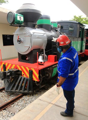 Funcionário da estação ao lado da Maria Fumaça