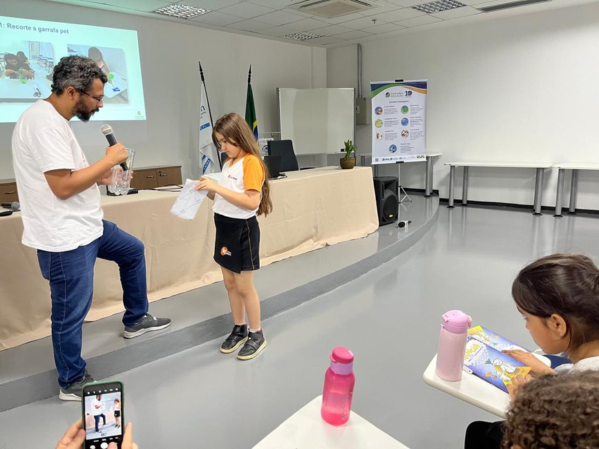 Aluna do 4º Ano do Ensino Fundamental, aprendendo a produzir um Pluvi-PET para monitorar  o nível  de chuvas.