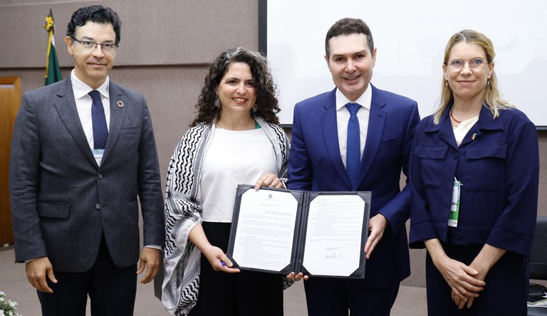 Na foto o ministro das cidades exibe o documento onde firma a parceria, junto aos representantes do InRede