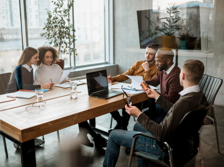 grupo de cinco pessoas reunidas em uma mesa