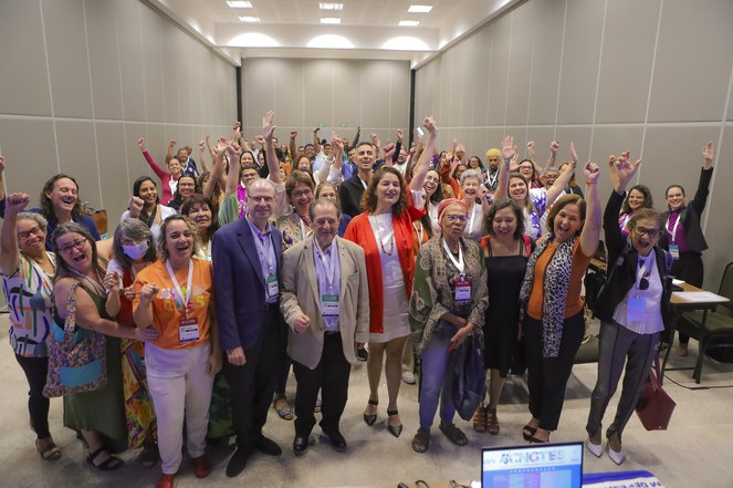 Descrição da imagem:Participantes da autogestionada em pé, posando para a foto. Ao fundo, sala onde ocorreu a atividade.