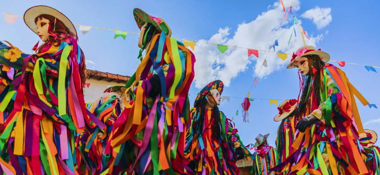 Homens vestidos com fantasias de fitas em festa junina.png