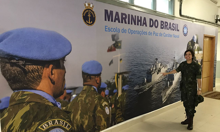 Maria Almeida junto a um grande painel com foto em homenagem à Marinha