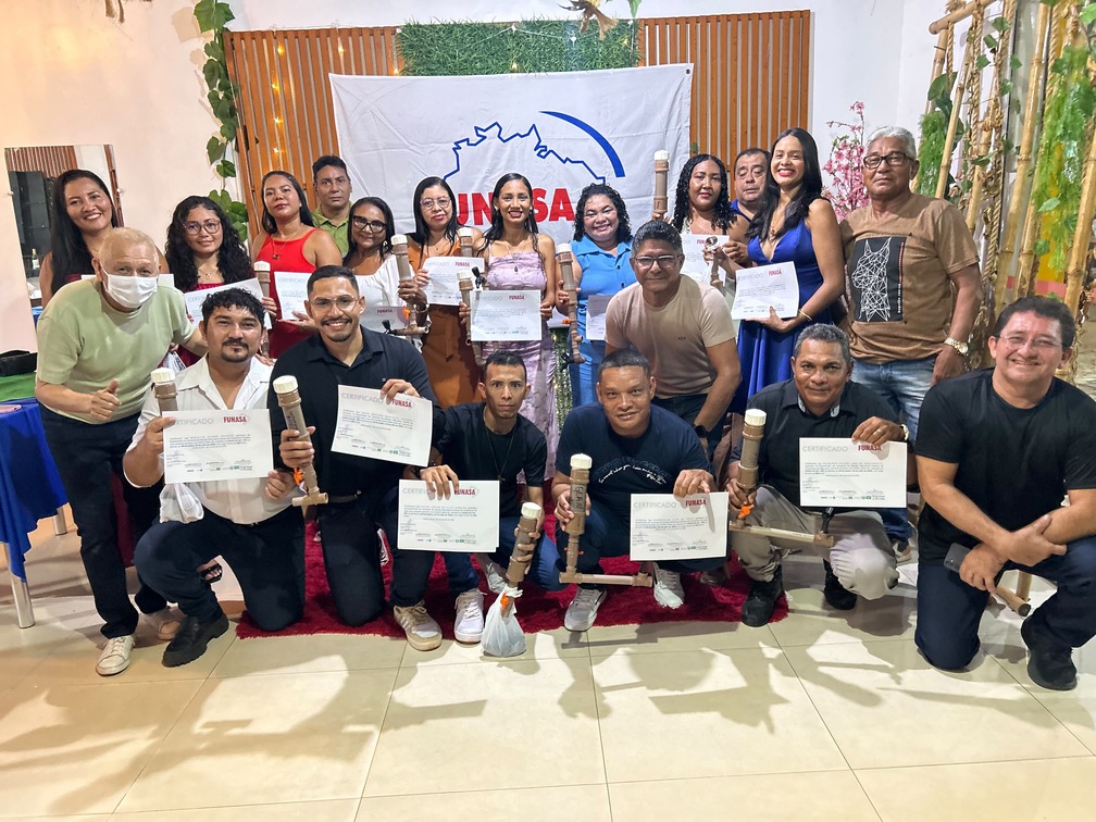 Grupo reunido segura certificados da Funasa e dosadores de cloro artesanais feitos de PVC marrom.