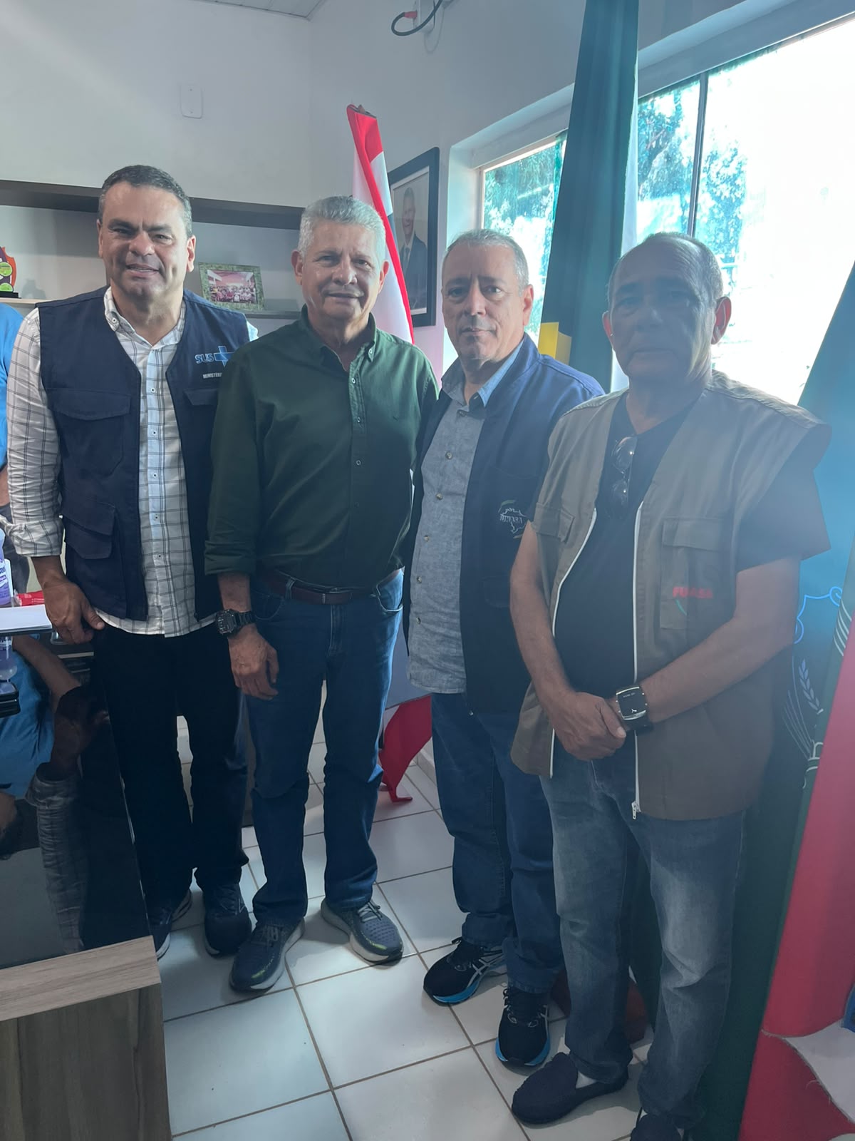 Quatro homens posando para foto em escritório de uma prefeitura.