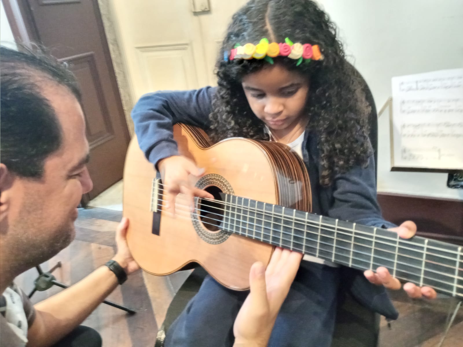 Aluna faz exploração tátil no violão em visita ao Museu Villa-Lobos