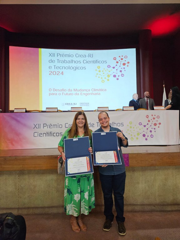 Thadeu Santos recebendo o Prêmio CREA-RJ com a professora Malu Moreira