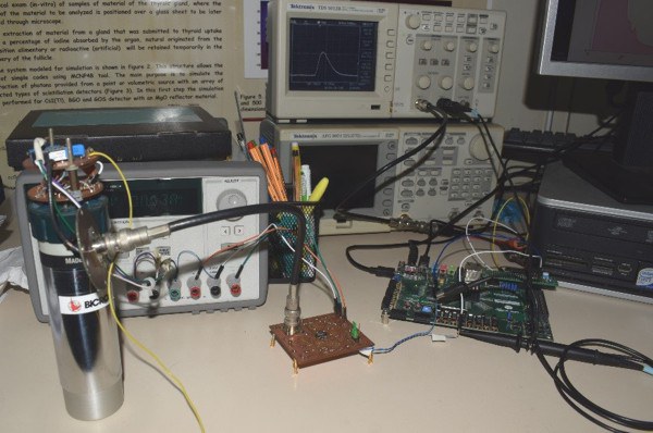 Sistema que está sendo desenvolvido no SEINS. À esquerda, a fotomultiplicadora, ao centro o circuito conformador de pulsos e, à direita, a placa onde está hardware do FPGA