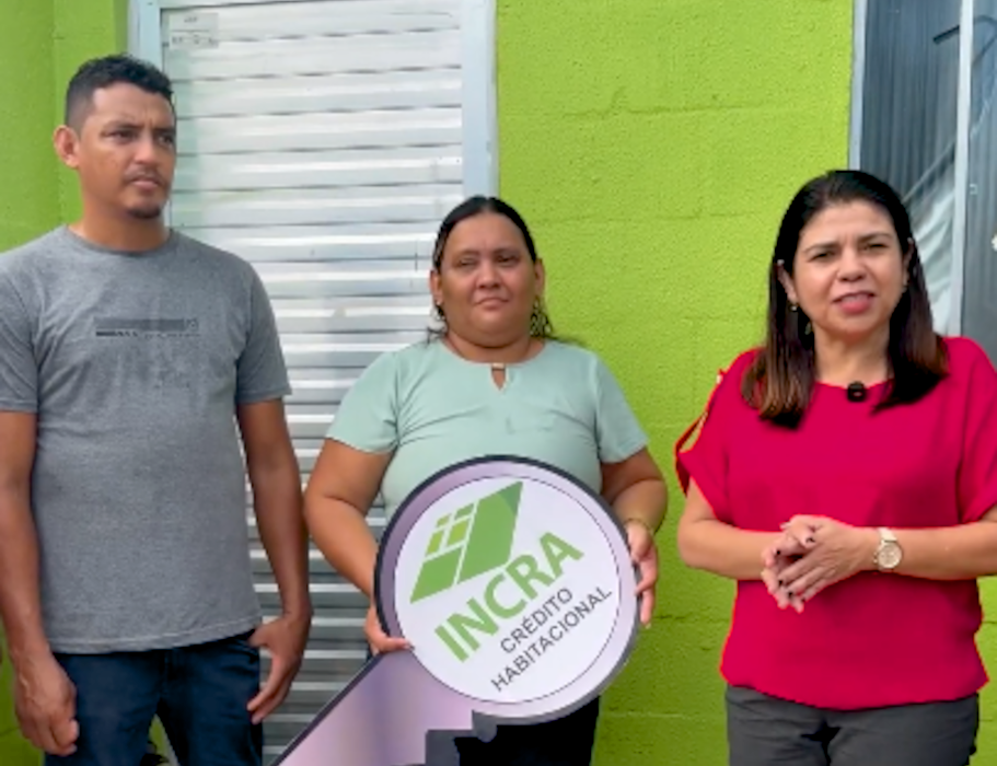 Imagem mostra casal recebendo simbolicamente crédito habitacional do Incra