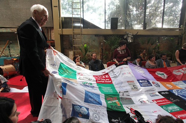 Zé Celso com a Bandeira das Liberdades Democráticas, símbolo das Caravanas da Anistia