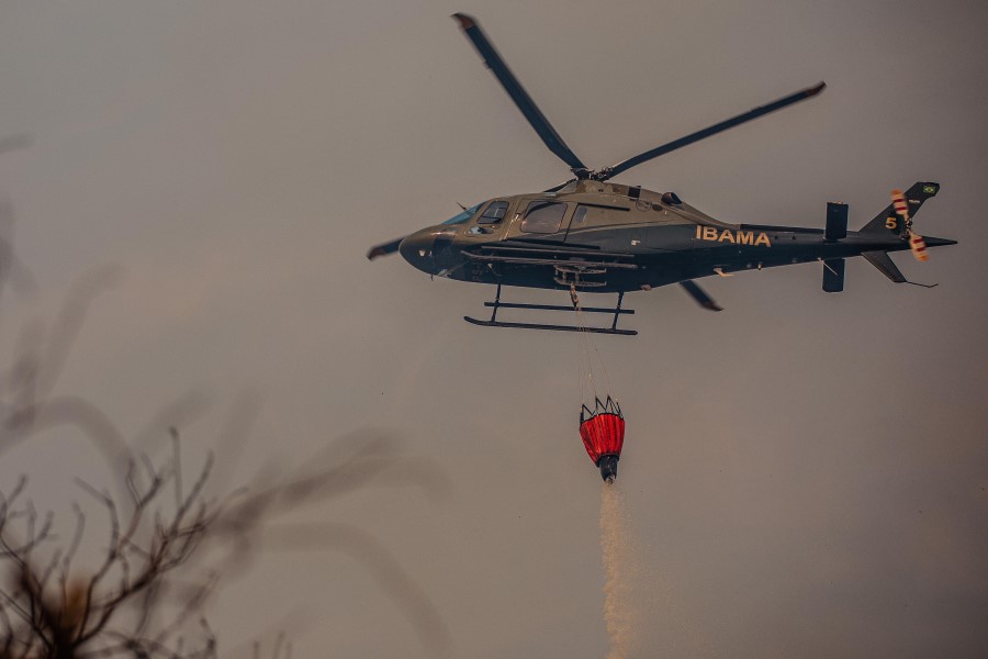 Helicóptero lança água para conter os incêndios