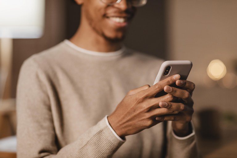 homem-sorridente-usando-smartphone-moderno.jpg