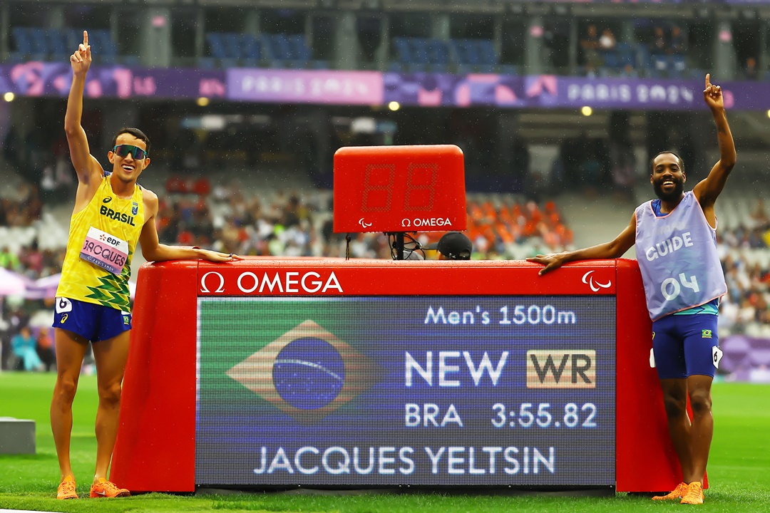 Yeltsin e o guia Guilherme dos Santos ao lado do recorde mundial estabelecido na final dos 1.500m. Foto: Silvio Avila/CPB