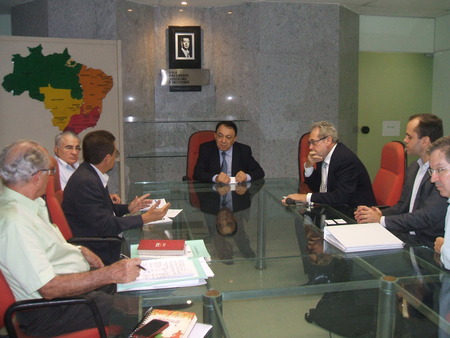 Várias pessoas sentadas ao redor de uma mesa e conversando entre si.