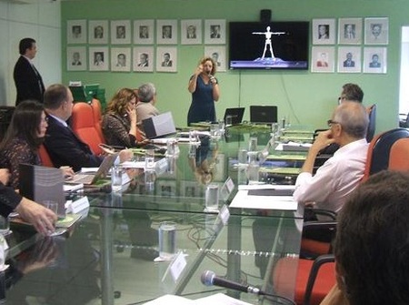 Várias pessoas sentadas ao redor de uma mesa.