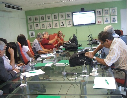 Várias pessoas sentadas numa mesa e conversando entre si.