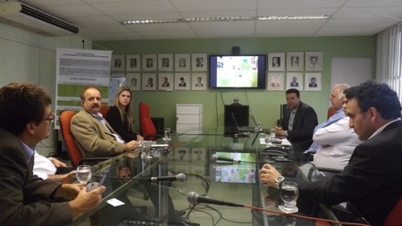 Várias pessoas sentadas ao redor de uma mesa e conversando entre si.