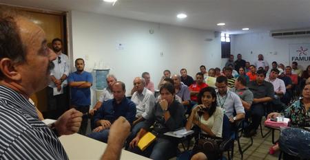 Foto do superintendente José Márcio discursando para prefeitos e secretários de municípios paraibanos. Há cerca de 50 pessoas em uma sala com cadeiras observando o superintendente falar. 