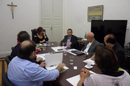 Foto com técnicos da Sudene e representantes do Governo da Paraíba sentados próximos a uma mesa debatendo a execução de um plano.