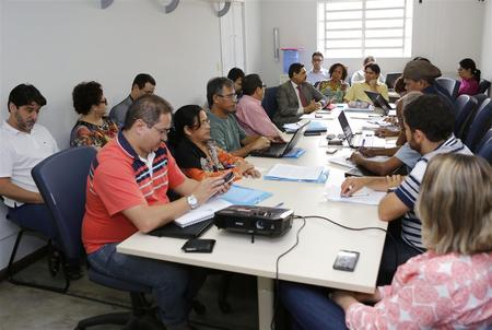 Várias pessoas conversando sentadas numa mesa.