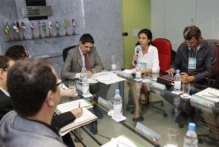 Várias pessoas sentadas numa mesa com o superintendente João Paulo Lima.