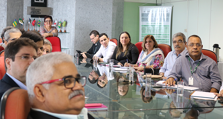 Gestores sentados na mesa da Sala JK, assistindo à palestra de Grazziotin