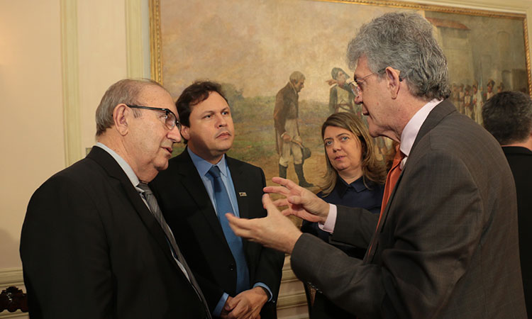 Superintendente Marcelo Neves conversando com três pessoas (todas em pé), sendo uma delas o governador da Paraíba, Ricardo Coutinho