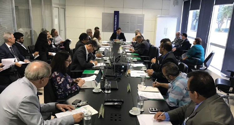 Foto do comitê técnico da Sudene. Há pessoas reunidas em uma mesa, falando entre si. Na ponta superior, está o superintendente Marcelo Neves.