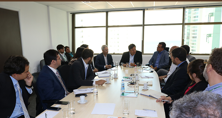 A foto trás um grupo de 15 pessoas sentadas em volta de uma mesa. Todas prestam atenção ao superintendente da Sudene, na ponta da mesa.