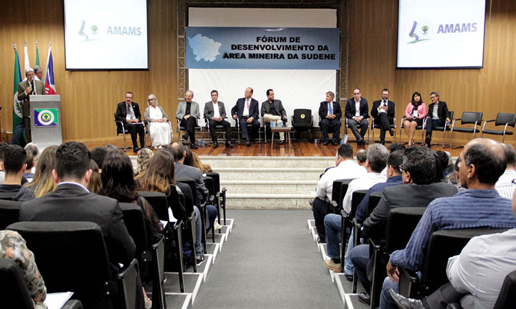 A foto mostra o diretor da Sudene no momento de sua apresentação. Ao lado, as autoridades da mesa de abertura. A imagem mostra, ainda, a plateia.