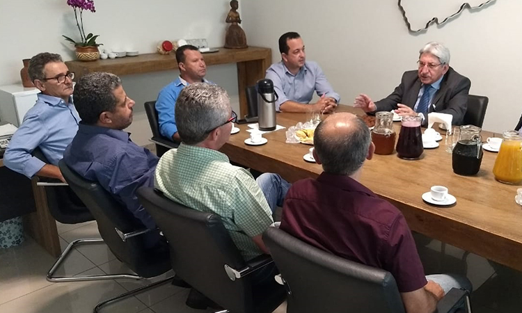 Participantes da reunião na AMAMS sentados à mesa.