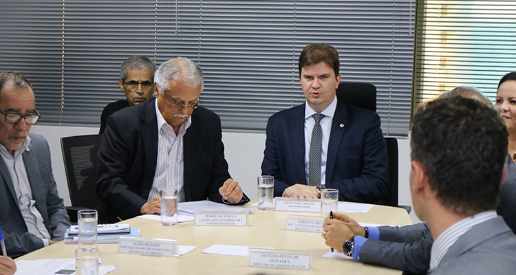 Foto da mesa de reunião, com destaque para o ministro e o superintendente.