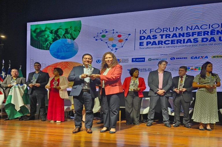 Palco com várias pessoas que receberam premiação reunidas